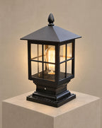 SCI Lighting Aldwin traditional pillar light lit with warm 3000K glow on a greige wall