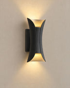 SCI Lighting Vega black and gold up-down LED outdoor wall light lit with warm 3000K glow on a greige wall