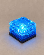 SCI Lighting Glacier solar ice cube step light with blue glow on a greige backdrop