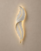 SCI Lighting Plume white feather wall light lit with warm 3000K glow on a greige wall