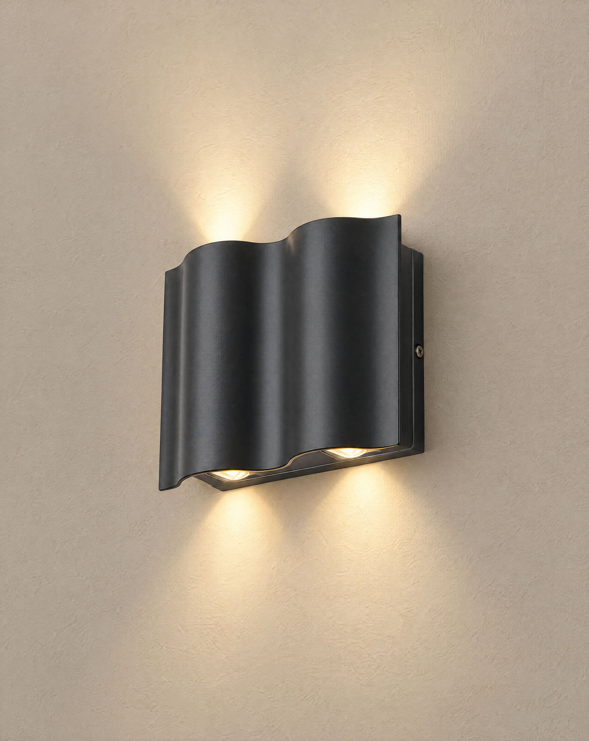 Solsence Onda 4-light black up-down LED outdoor wall light lit with warm 3000K glow on a greige wall