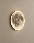 SCI Lighting Orbis moon wall light lit with warm 3000K glow on a greige wall