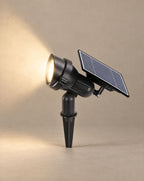 SCI Lighting Beacon solar spotlight lit with warm 3000K glow against a greige backdrop