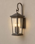SCI Lighting Harlow outdoor wall lantern lit with warm 3000K glow on a greige wall