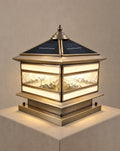 Solsence Halcyon solar copper pillar light lit with warm 3000K glow on a greige wall