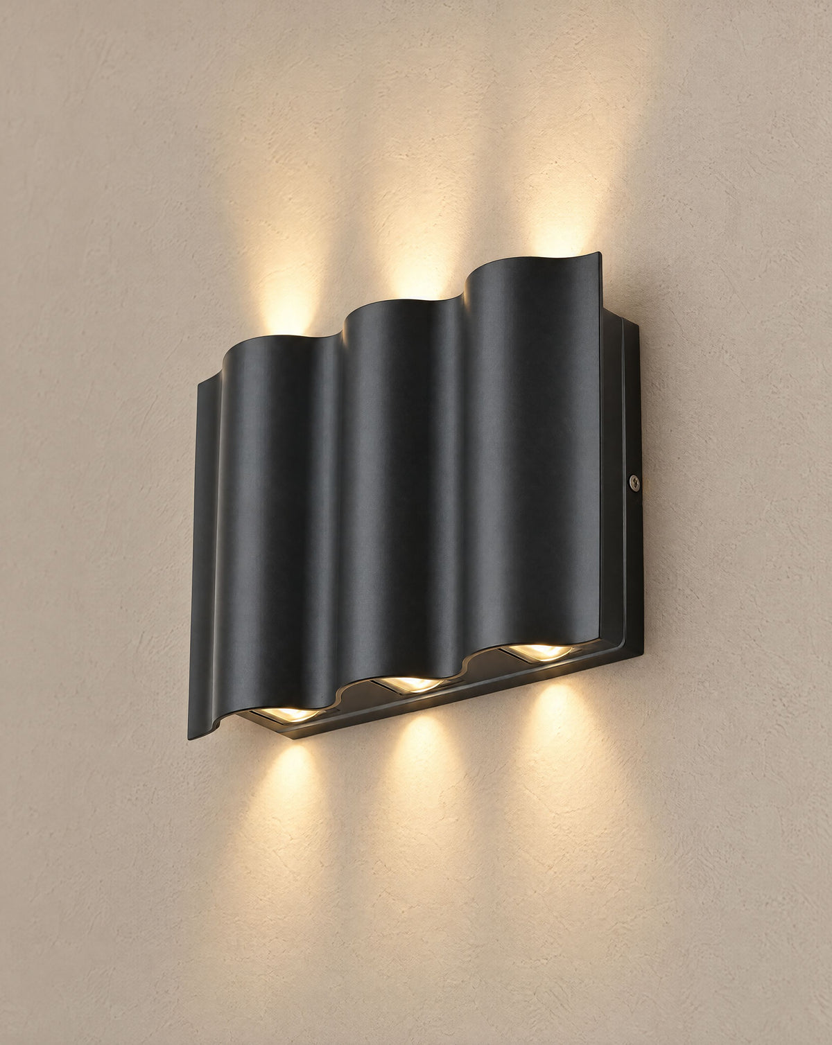 Solsence Onda 6-light black up-down LED outdoor wall light lit with warm 3000K glow on a greige wall