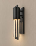 Solsence Sable outdoor wall light lit with warm 3000K glow on a greige wall