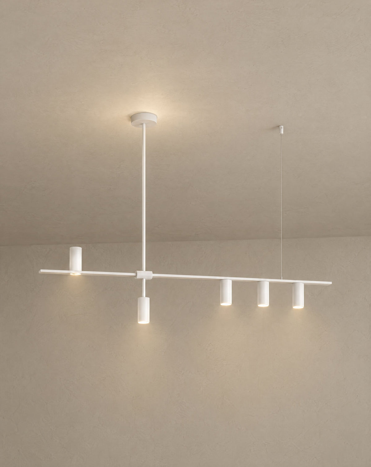 Solsence Cylo white cylinder ceiling light lit with warm 3000K glow against a greige backdrop