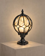 SCI Lighting Marlowe black globe pillar light lit with warm 3000K glow on a greige wall