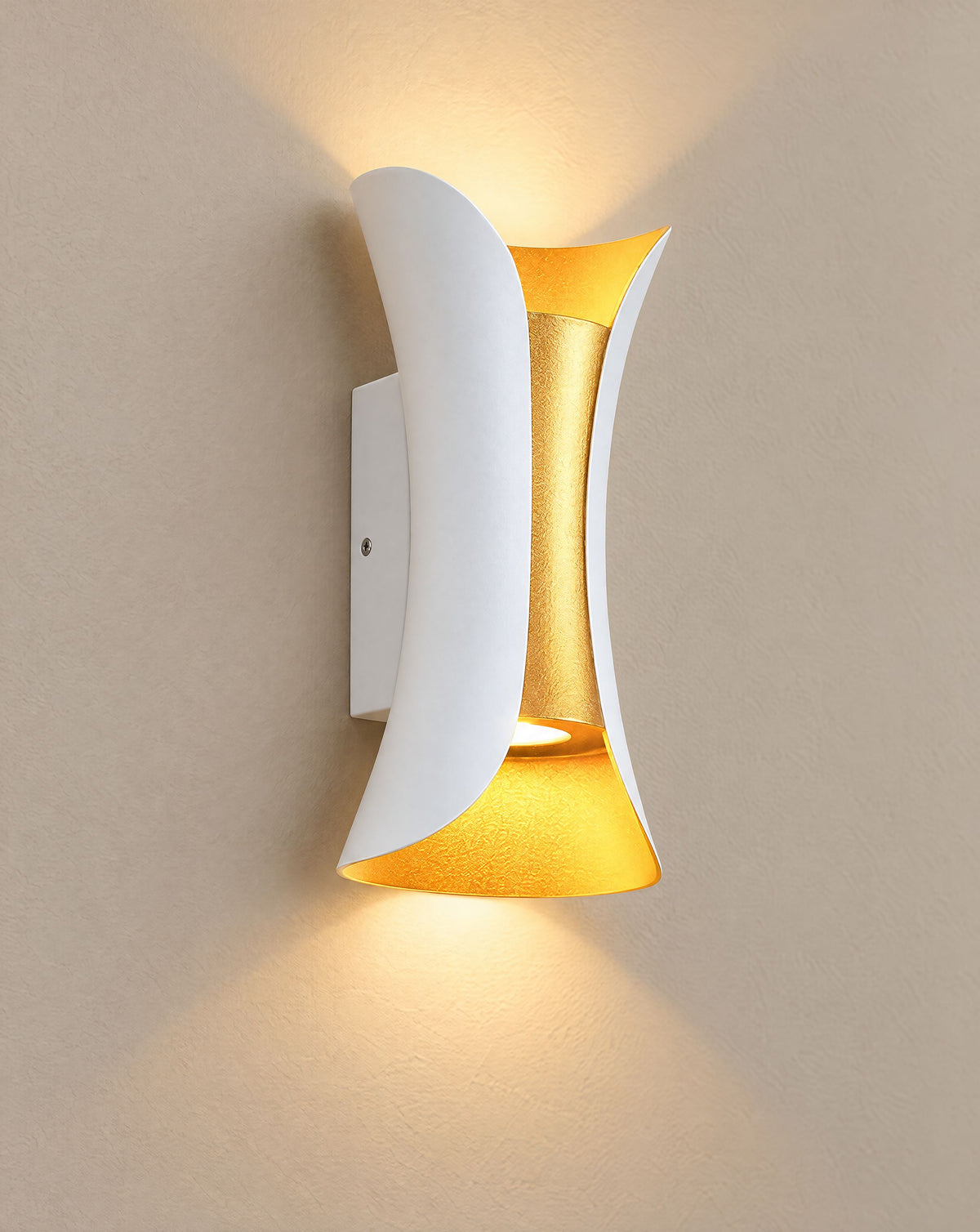 Solsence Vega white and gold up-down LED outdoor wall light lit with warm 3000K glow on a greige wall