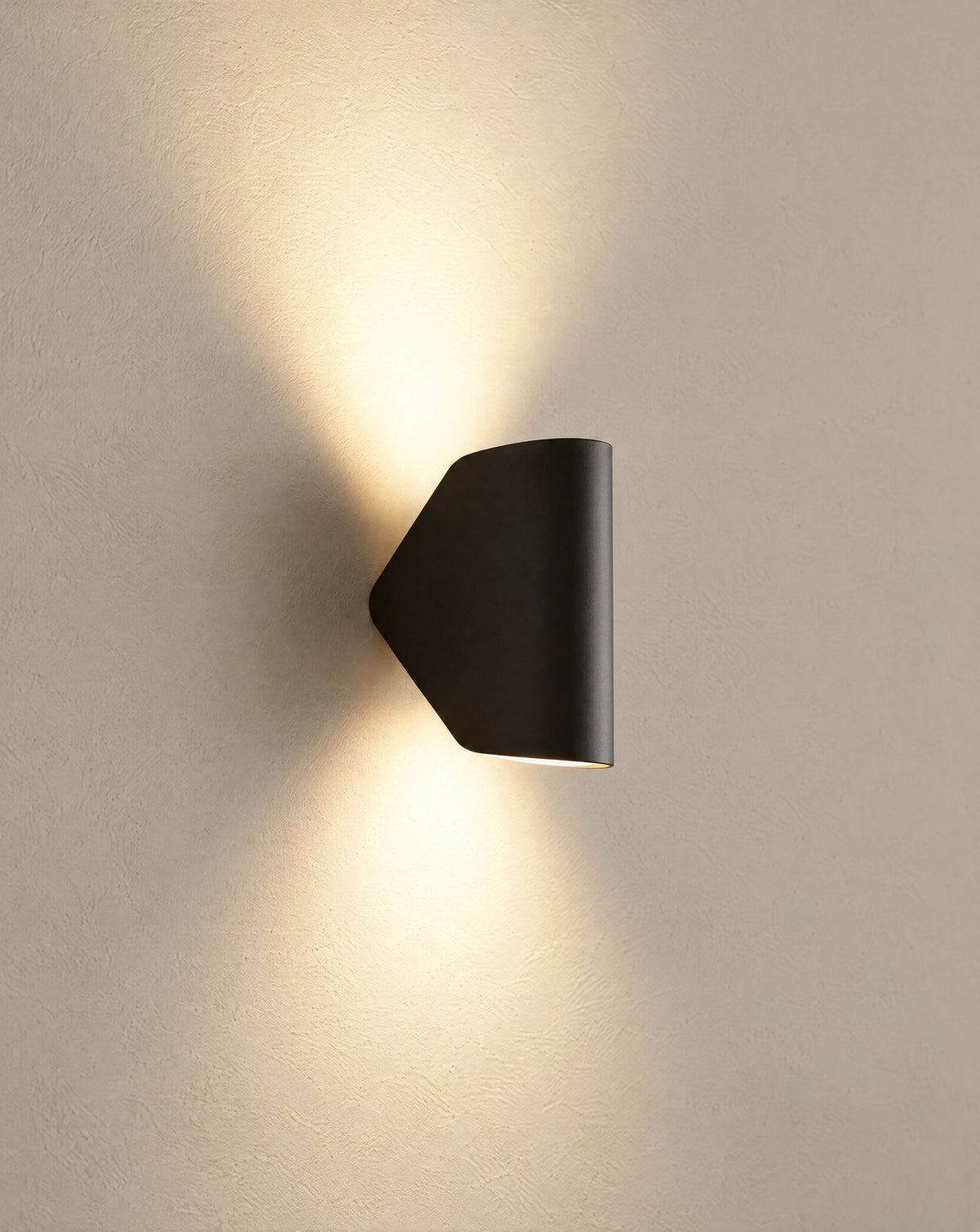 Solsence Pivot outdoor wall light - Black lit with warm 3000K glow on a greige wall