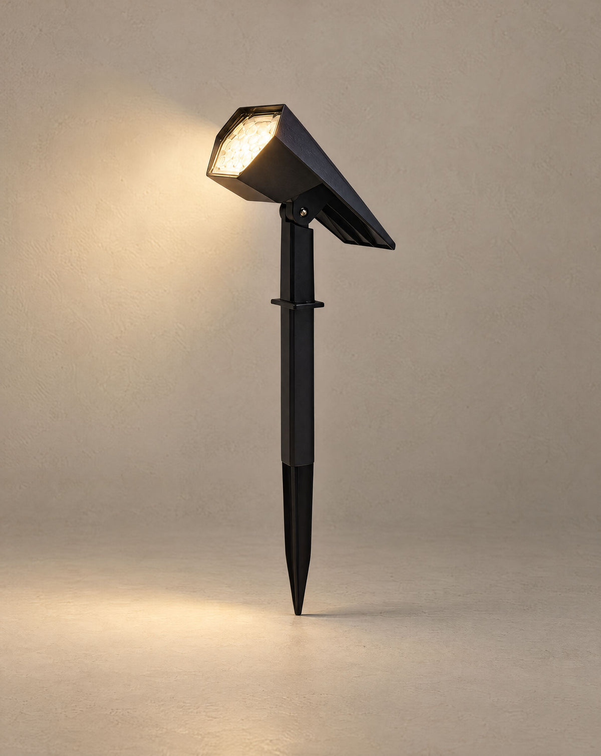 Solsence Vireo solar spike light lit with warm 3000K glow against a greige backdrop