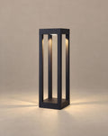 SCI Lighting Sentry 4-beam bollard light lit with warm 3000K glow against a greige backdrop