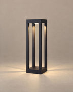 SCI Lighting Sentry 4-beam bollard light lit with warm 3000K glow against a greige backdrop