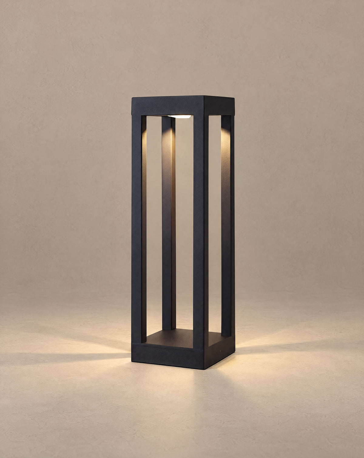 Solsence Sentry 4-beam bollard light lit with warm 3000K glow against a greige backdrop