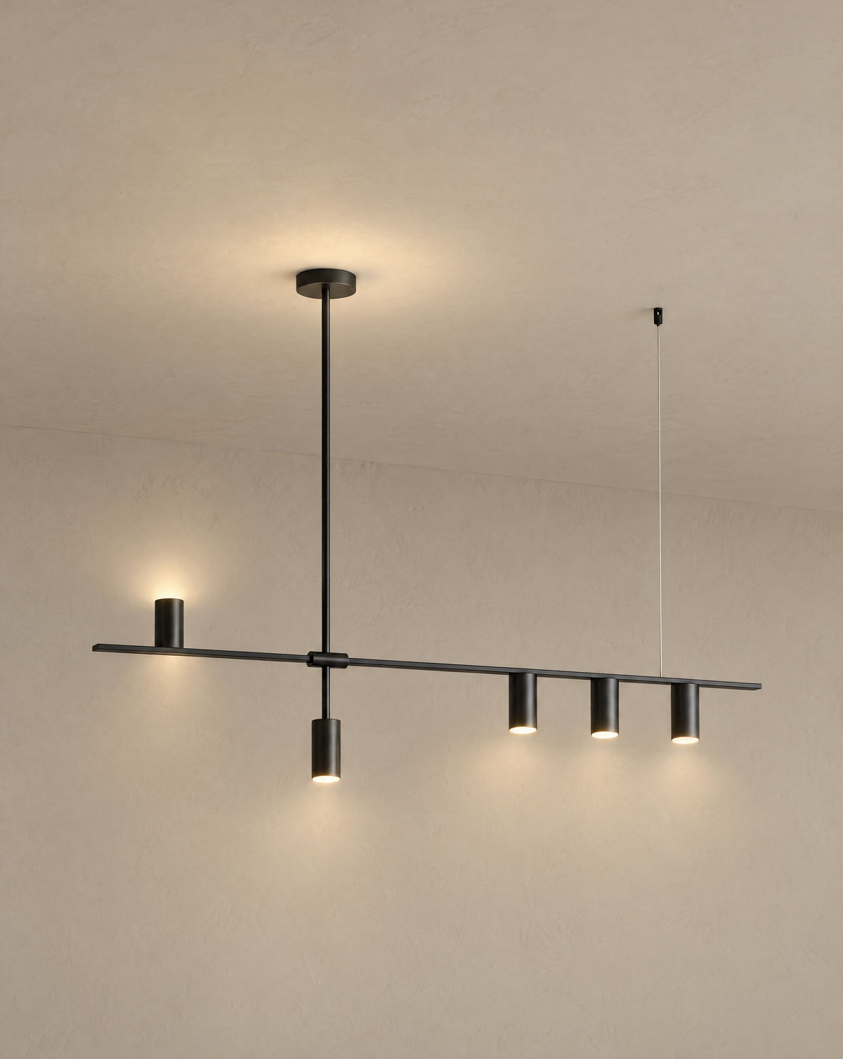 Solsence Cylo black cylinder ceiling light lit with warm 3000K glow against a greige backdrop