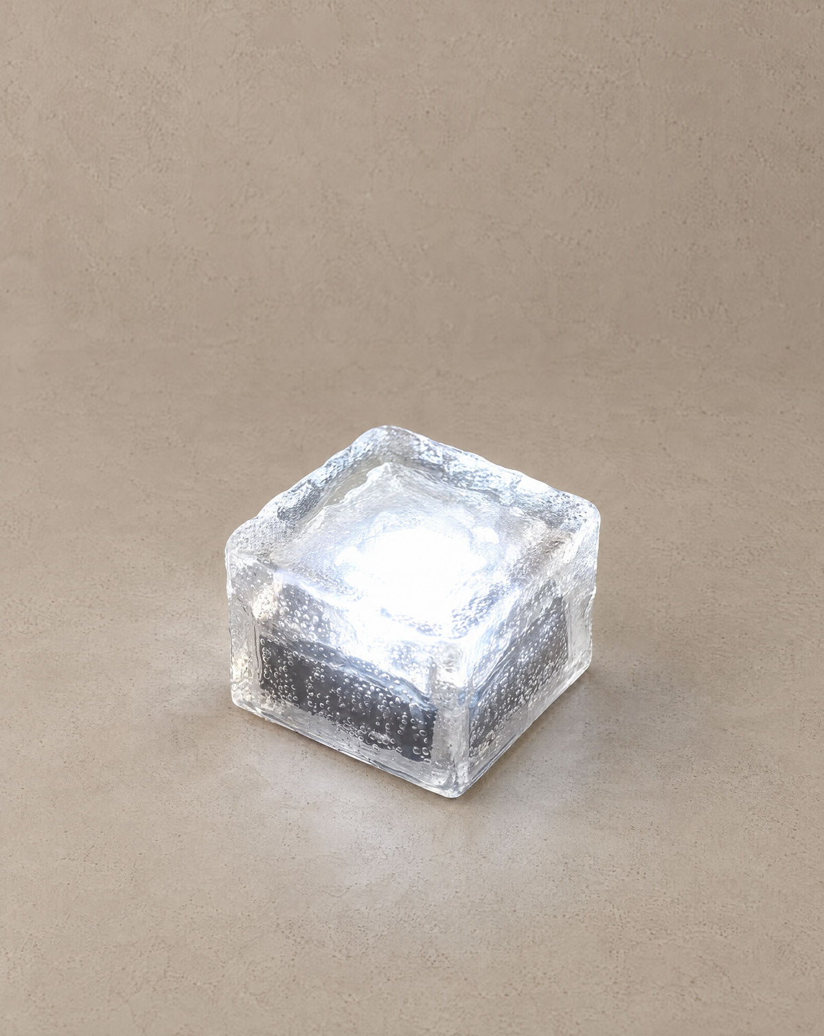 Solsence Glacier solar ice cube step light with white 6000K glow on a greige backdrop