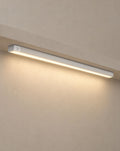 Solsence Vela wireless motion sensor light bar - Silver lit with warm 3000K glow under a greige microcement shelf