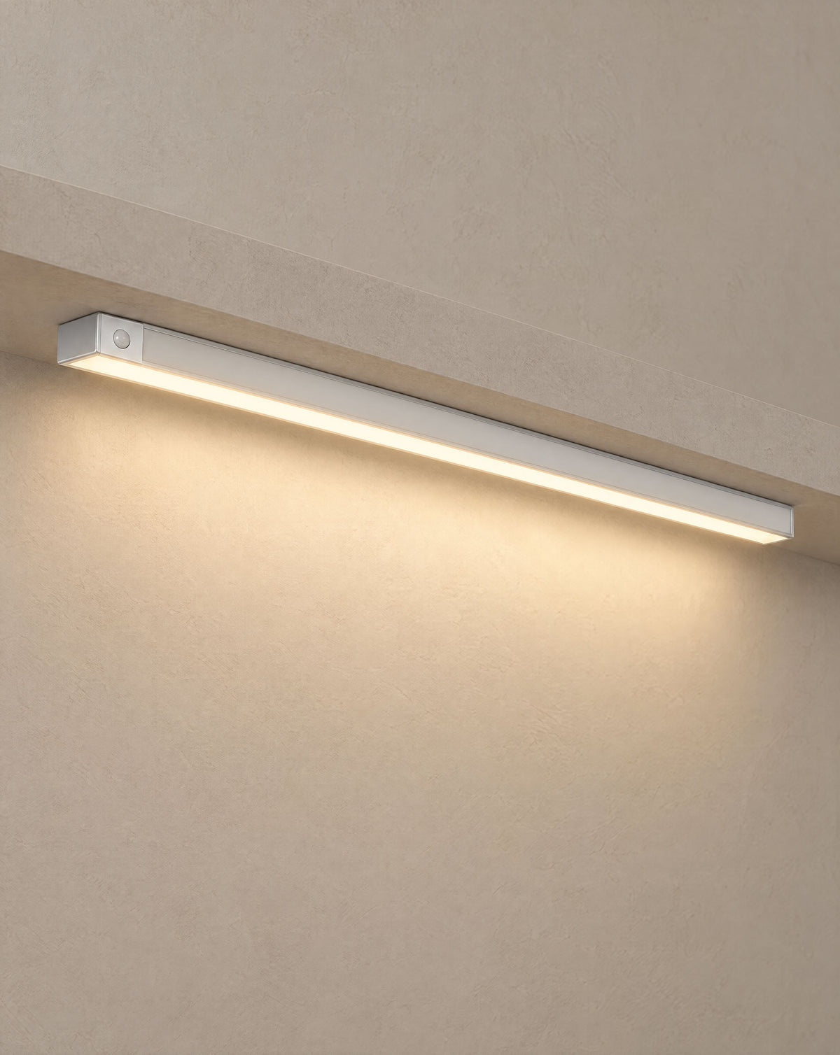Solsence Vela wireless motion sensor light bar - Silver lit with warm 3000K glow under a greige microcement shelf