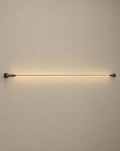Solsence Strand black linear LED strip light lit with warm 3000K glow against a greige backdrop