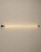 Solsence Strand black linear LED strip light lit with warm 3000K glow against a greige backdrop