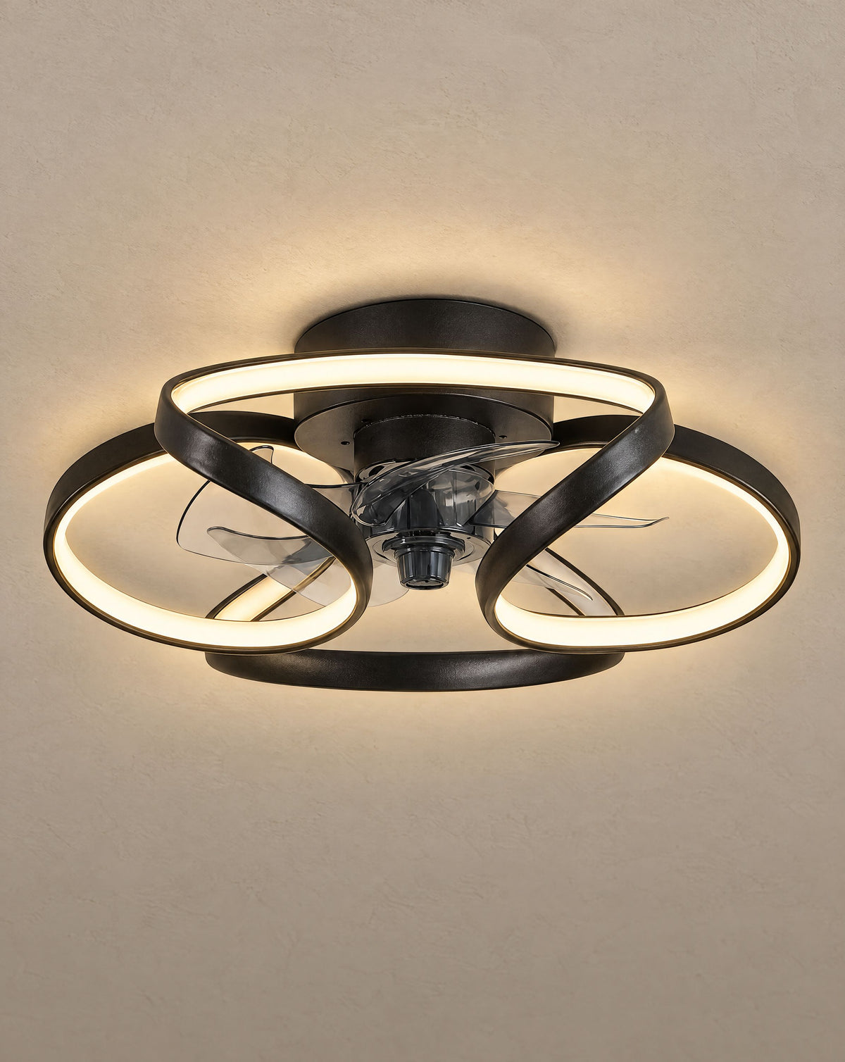 Solsence Petal black flower ceiling fan with light lit with warm 3000K glow against a greige backdrop