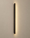 SCI Lighting Axis slim black LED linear outdoor wall sconce lit with warm 3000K glow on a greige wall
