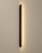 SCI Lighting Axis slim black LED linear outdoor wall sconce lit with warm 3000K glow on a greige wall