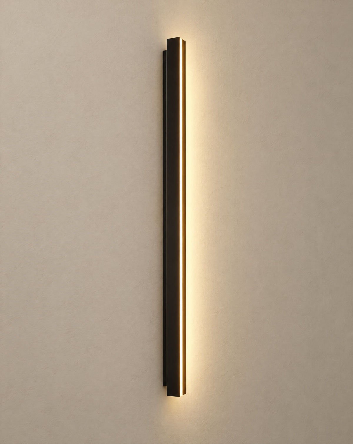 Solsence Axis slim black LED linear outdoor wall sconce lit with warm 3000K glow on a greige wall