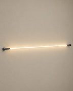 Solsence Strand white linear LED strip light lit with warm 3000K glow against a greige backdrop