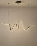 Solsence Lyra linear pendant light lit with warm 3000K glow on a greige wall