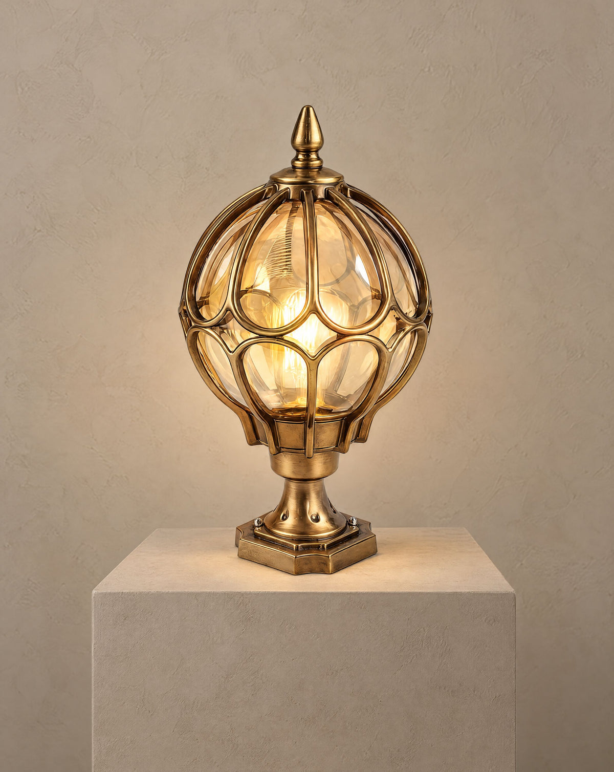 Solsence Marlowe bronze globe pillar light lit with warm 3000K glow on a greige wall