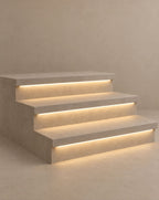 SCI Lighting Stairline under-tread LED strip light lit with warm 3000K glow against a greige backdrop