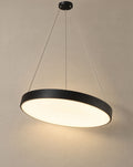 Solsence Halo black round LED ring pendant light lit with warm 3000K glow in front of a greige wall