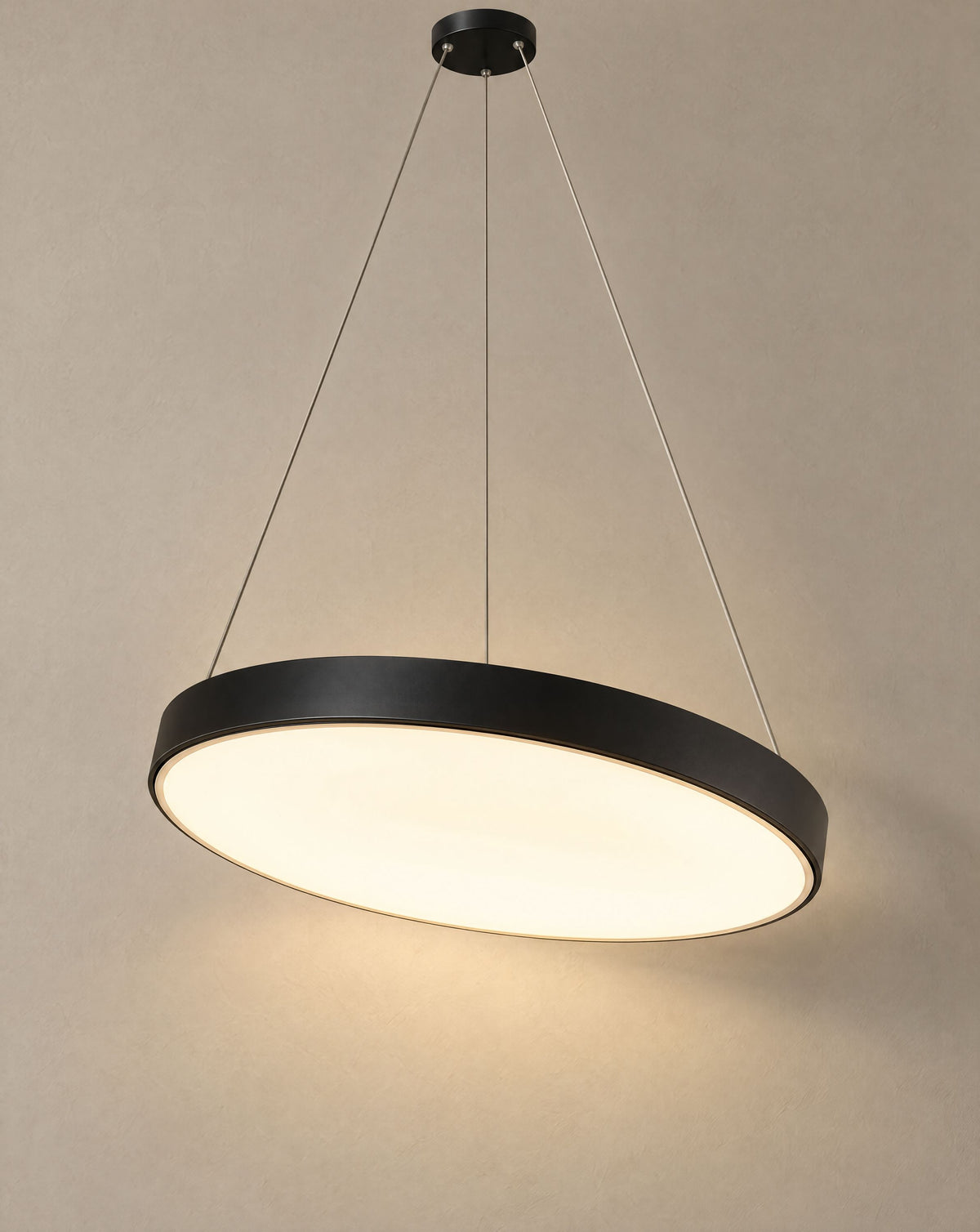 Solsence Halo black round LED ring pendant light lit with warm 3000K glow in front of a greige wall