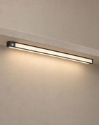 Solsence Vela wireless motion sensor light bar - Black lit with warm 3000K glow under a greige microcement shelf