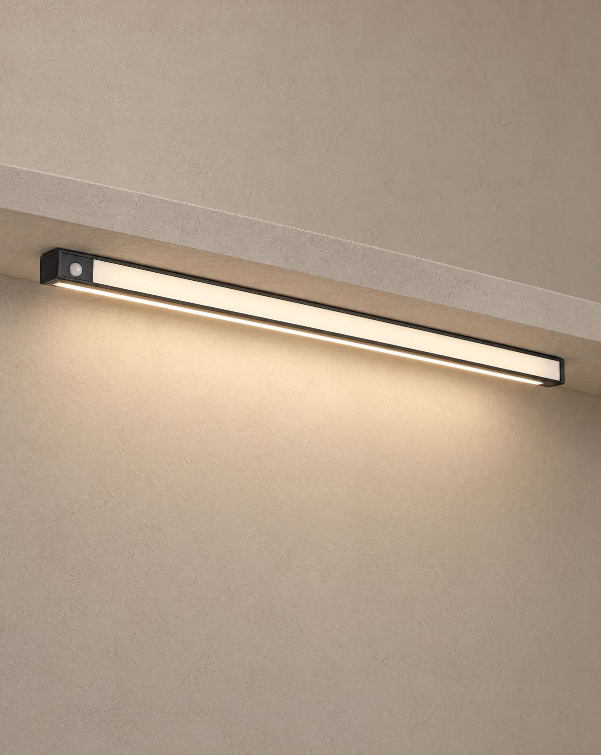 Solsence Vela wireless motion sensor light bar - Black lit with warm 3000K glow under a greige microcement shelf