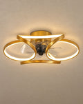 SCI Lighting Petal gold flower ceiling fan with light lit with warm 3000K glow against a greige backdrop