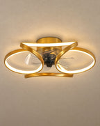 SCI Lighting Petal gold flower ceiling fan with light lit with warm 3000K glow against a greige backdrop