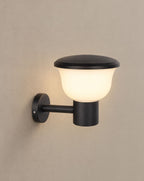 Solsence Chalice hardwired cup outdoor wall light lit with warm 3000K glow on a greige wall